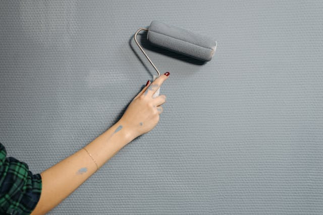 person-painting-wall-grey